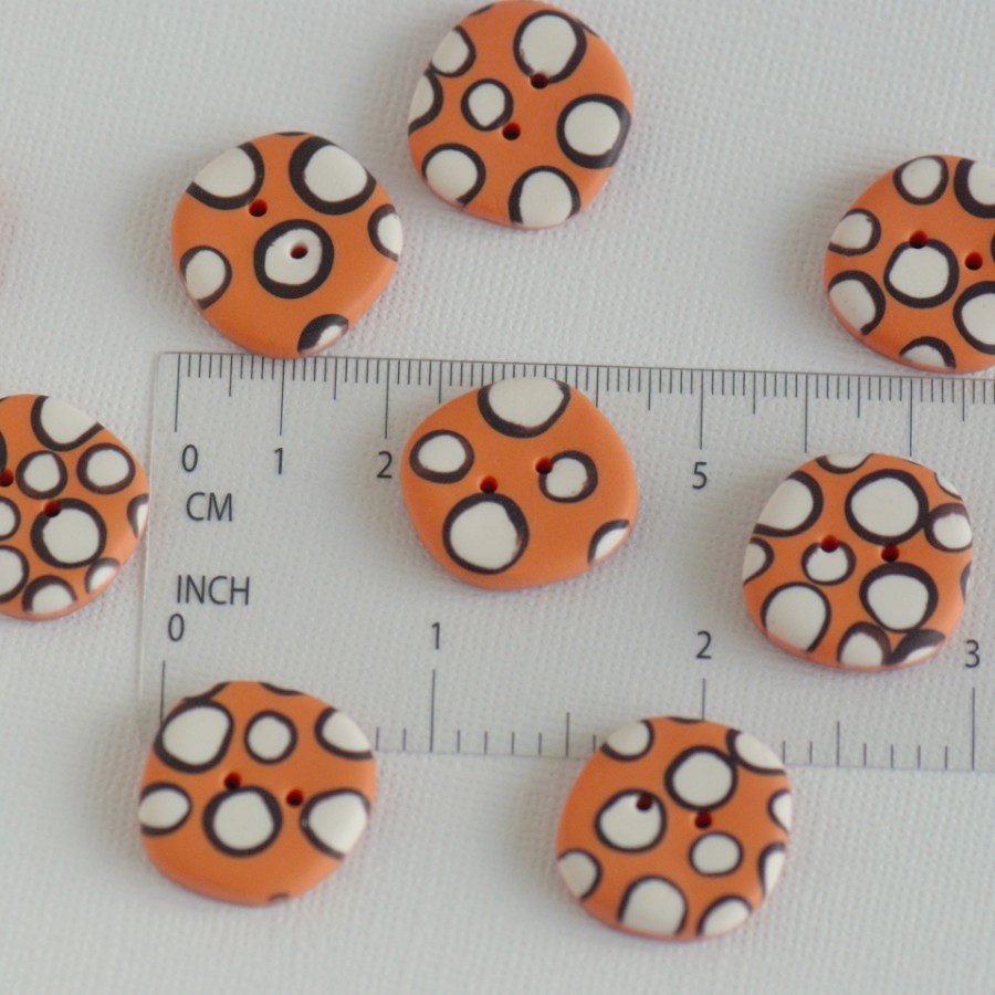 21 mm – 9 vnt. netaisyklingos apvalaino keturkampio formos oranžinės taškuotos sagos