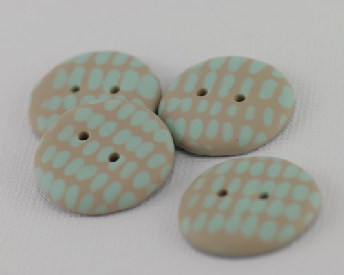 23 mm – 4 vnt. Smėlio rusvos spalvos sagos su mėtinės žalsvos spalvos ornamentu (BT208)