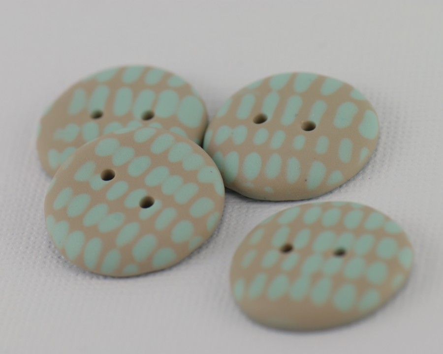 23 mm – 4 vnt. Smėlio rusvos spalvos sagos su mėtinės žalsvos spalvos ornamentu (BT208)