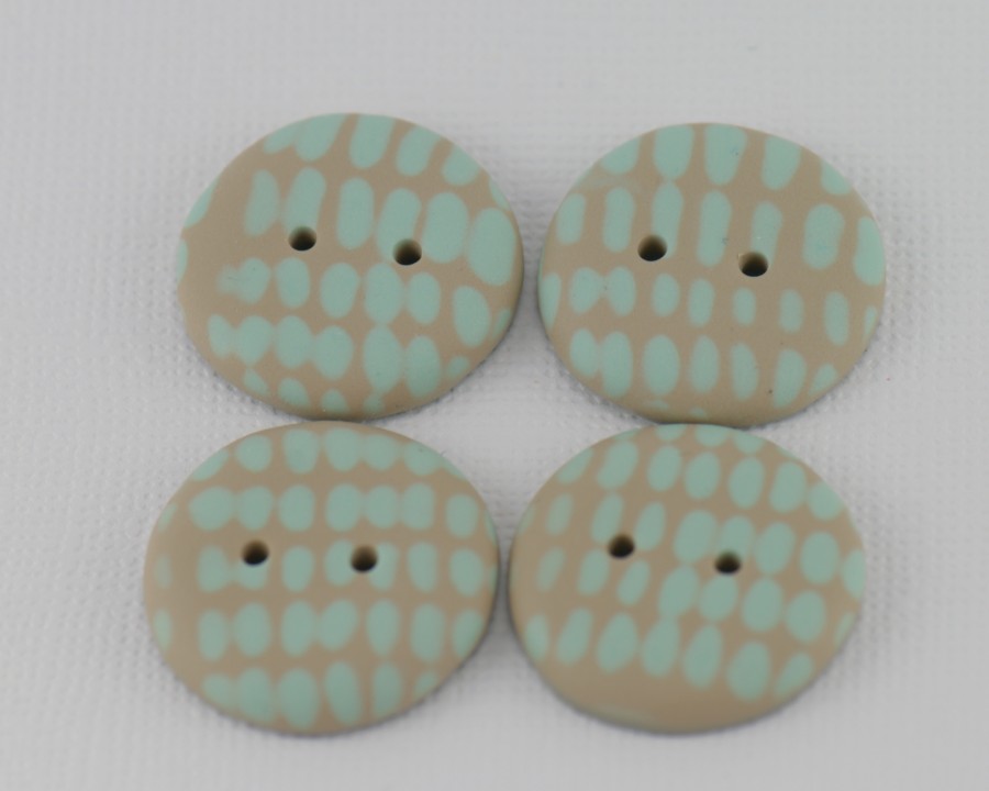 23 mm – 4 vnt. Smėlio rusvos spalvos sagos su mėtinės žalsvos spalvos ornamentu (BT208)