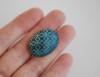 Ovali sagė „Šaltos žalios ornamentai tamsiame fone“ (pin07)