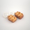 Žaismingi kabantys auskarai „Brioche“ Žaismingi kabantys auskarai „Brioche“
